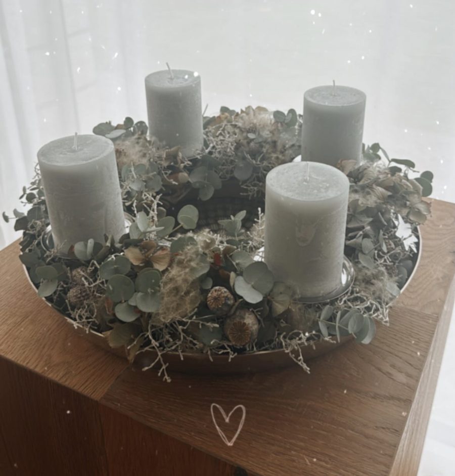 Adventskranz mit Eukalyptus und drei Kerzen auf silberner Schale